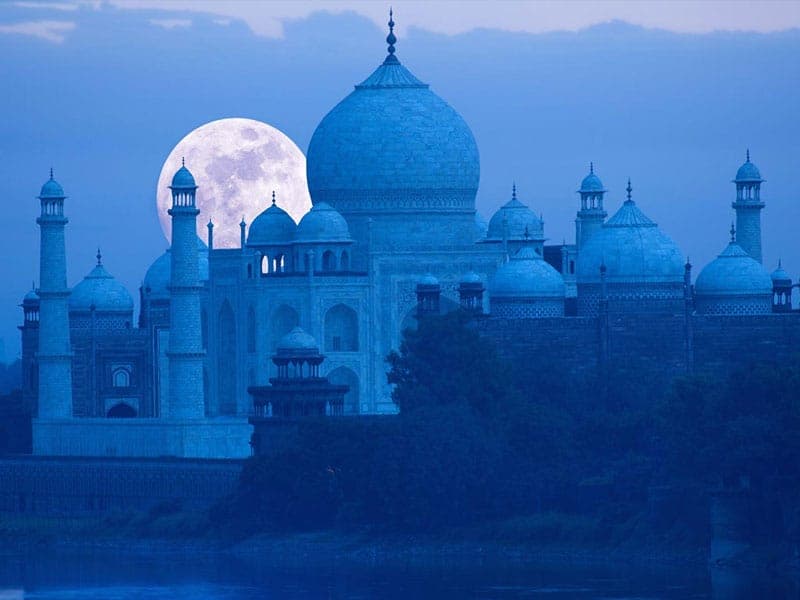 Full moon rising behind the Taj Mahal
